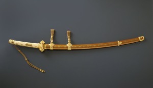 Mounting for a ceremonial long sword (tachi) with nine planet family crests and gold fittings, Japan. Edo period (1615–1868), 19th century. Lacquered wood with sprinkled gold (makie) decoration, gilt bronze, gold, ray skin, leather. Eisei Bunko Museum, 29241. © Eisei Bunko, Japan.